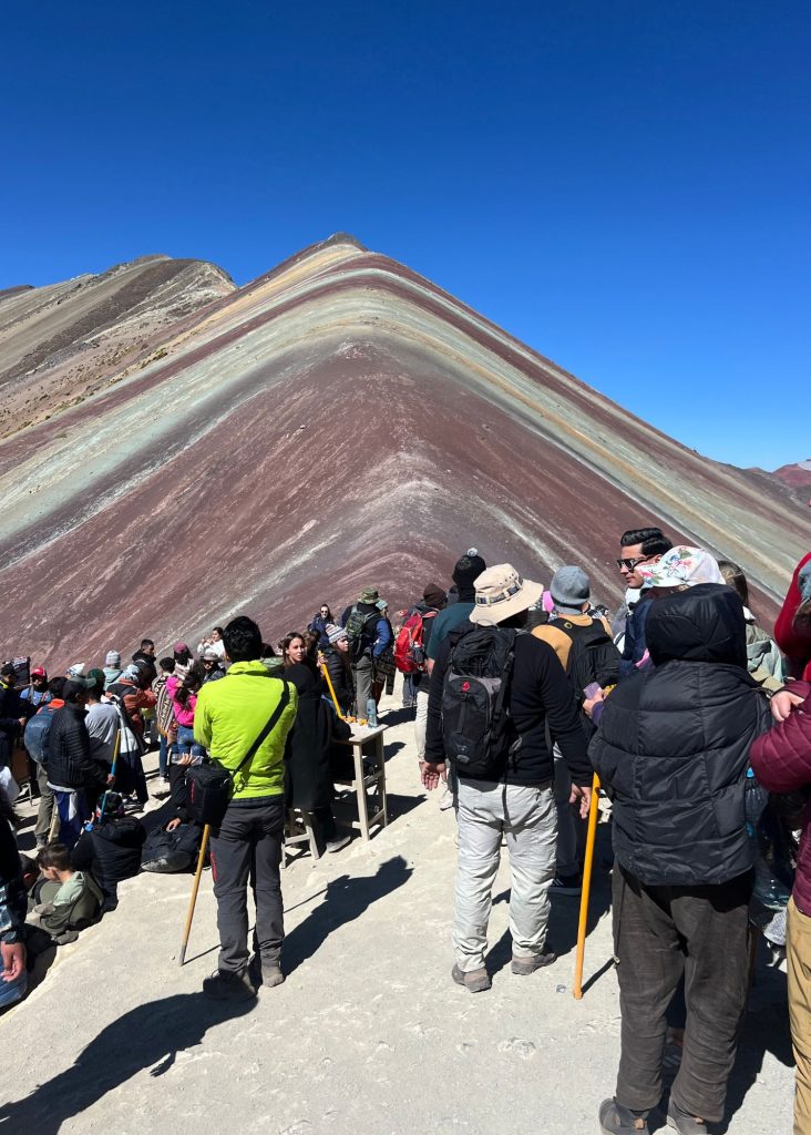 la gente haciendo fila para sacarse una foto en la montaña de 7 colores
