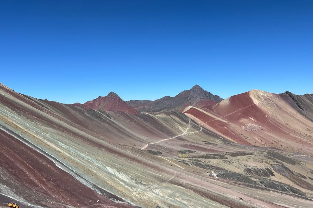 Uno de los lugares que hay que visitar en Perú es la montaña de siete colores que se ve en la foto, para ilustrar el post sobre como llegar