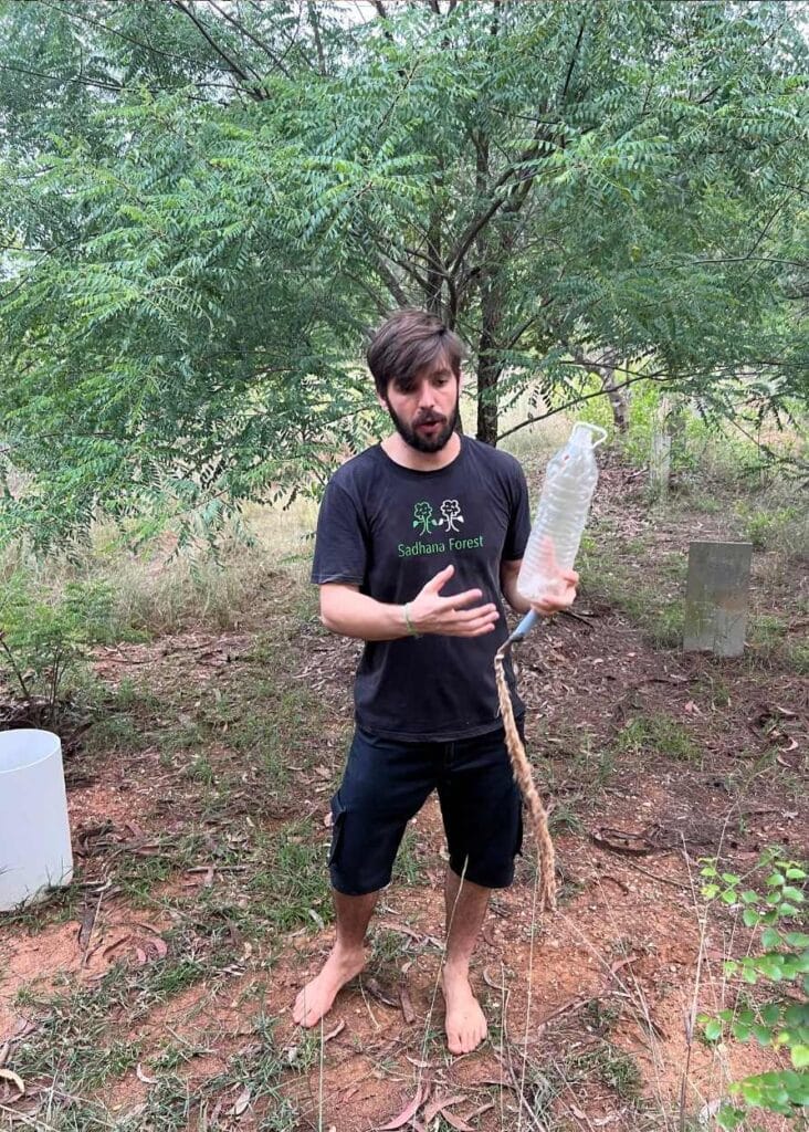 El voluntario de SAdhana Forest contándonos como plantan los árboles
