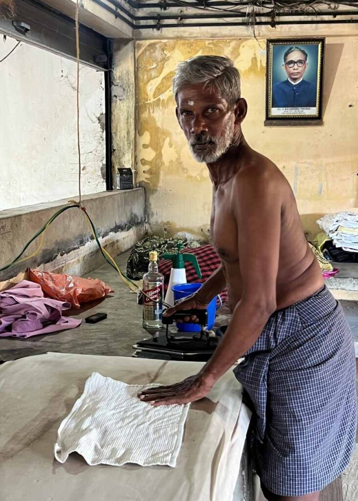 Un hombre planchando ropa en Kochi
