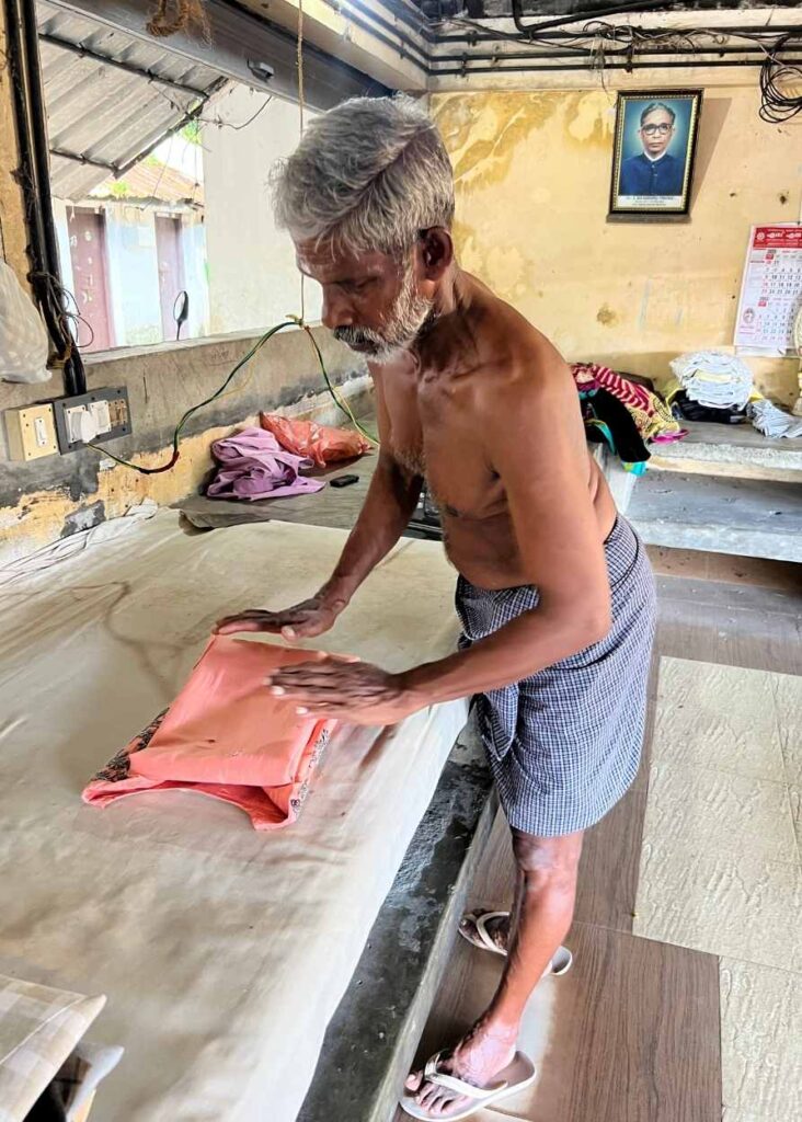 Un hombre doblando ropa en Kochi