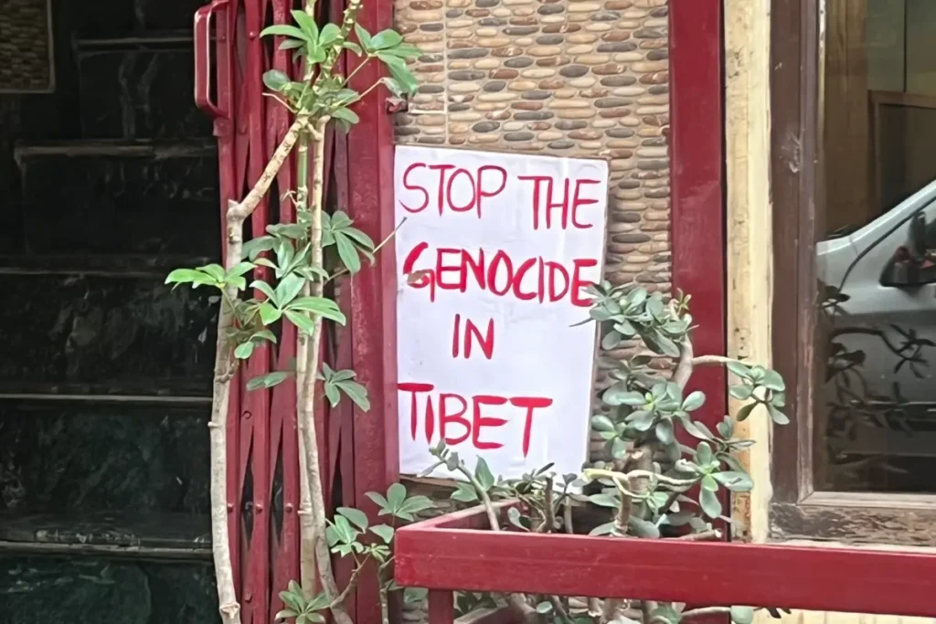 Un cartel que dice "stop the genocide in tibet"